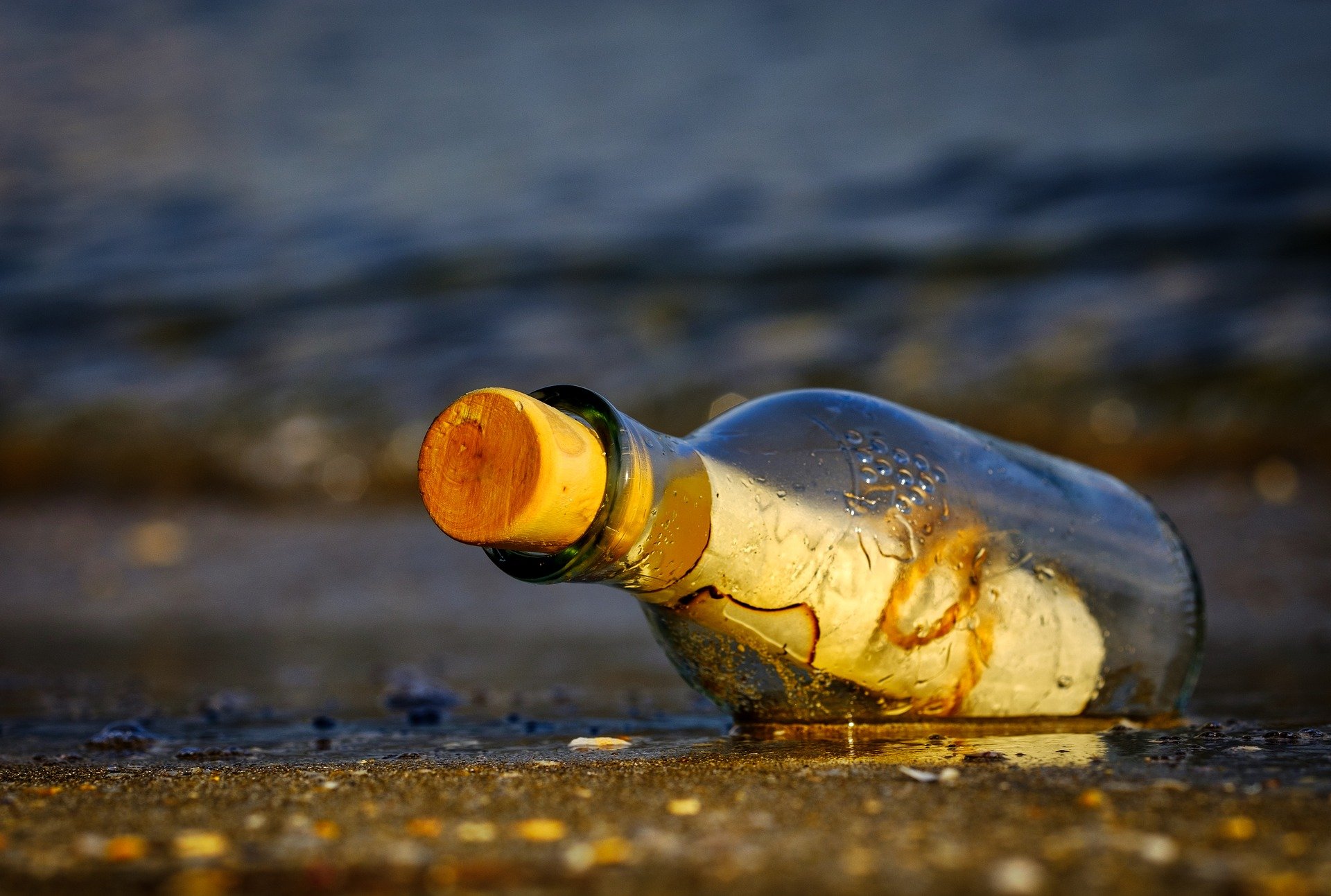A message in a bottle lying on a beach.